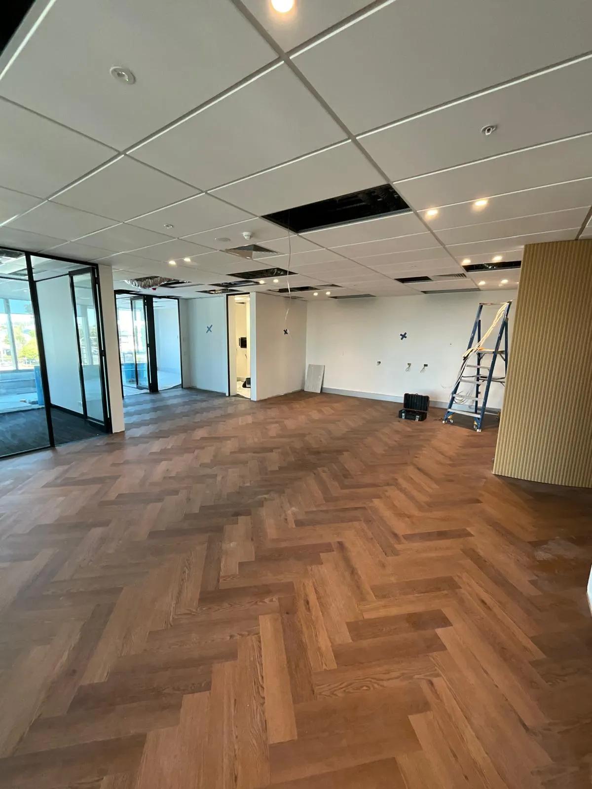 Ongoing office ceiling and lighting installation at a commercial property in Sydney with new hardwood flooring